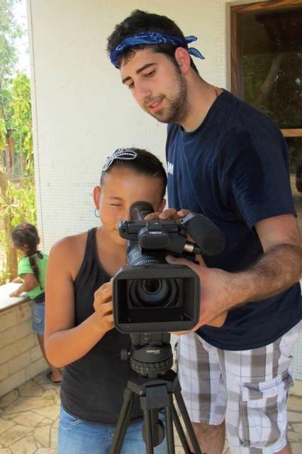 一个学生在帮一个孩子拿摄像机