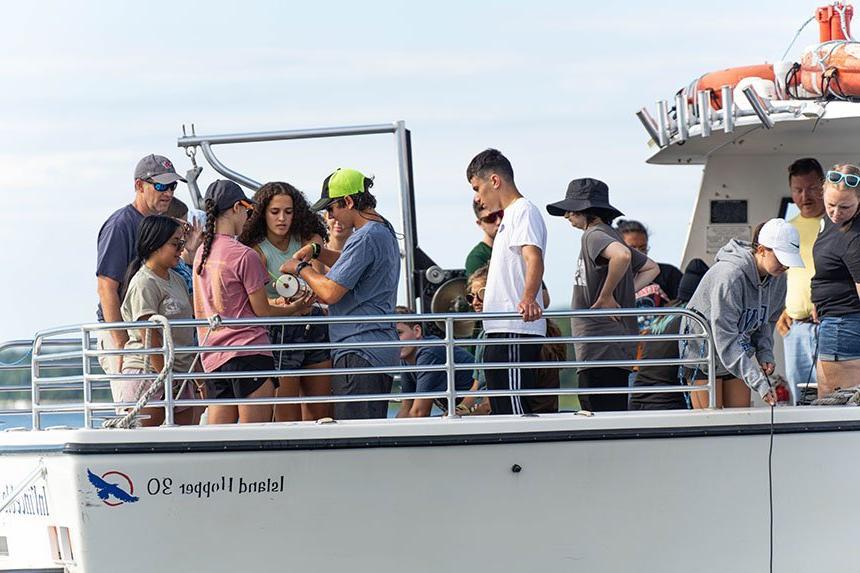 Students handling a water collection device on the InVinceble Spirit. 